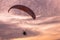 Paraglider flying at sunset