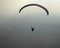 Paraglider flying wings on a misty morning