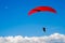 The paraglider hovers in the sky high above the clouds