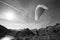 Paraglider Pilot stands on a slope and balances his paraglider above his head in the Alps of Switzerland