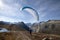 Paraglider Pilot takes off with his paraglider to take off and fly into the valley in the Swiss Alps