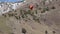 Paraglider With Red Parachute Gliding In front of Mountains