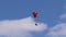 Paraglider With Red Parachute Wing Flying in a Blue Sky With Clouds