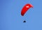 Paraglider with red wing shape on the blue sky in Interlaken, Switzerland.