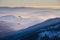 Paraglider silhouette flying over misty mountain valley in beautiful warm sunset colors - sport, active wallpapers full of freedom