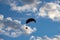 Paraglider silhouette over blue sky