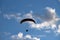 Paraglider silhouette over blue sky