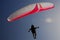 A paraglider soaring like a bird into the sun