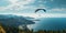 A paraglider soars over the sea and forest, revealing a breathtaking view from above that takes your breath away