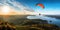 A paraglider soars over the sea and forest, revealing a breathtaking view from above that takes your breath away