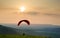 Paraglider takes off over countryside landscape