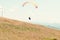 Paraglider taking off from green hill