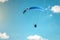 Paraglider wing flying in blue cloudless sky