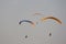 Paragliders against the blue sky. Bright paragliders fly in the