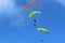 Paragliders flying wings in a blue sky