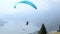 Paragliders landing and taking off from mountain slope near Locarno