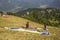 Paragliders on the mountainside prepare to take off on the background of green mountains and houses in