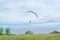 Paragliding Extreme Sport Concept. A paraglider flies in the sky in a cocoon suit on a paraglider against the sky and clouds.