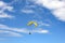 Paragliding flight with blue sky and some clouds