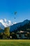 Paragliding flying over green field Hohematte park and Swiss alps in Interlaken, Switzerland