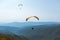Paragliding in mountains. Freedom to fly in air over mountains with parachute. Paragliding behind blue sky Carpathian