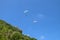 Paragliding in the sky. Two single paragliders flying in bright sunny day over tropical Bali island. Beautiful paraglider on a