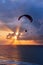 Paragliding at sunset on sea with sun beams