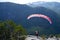 Paragliding. Woman with a red paraglider on the top of the mountain.