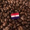 A Paraguay flag placed over roasted coffee beans