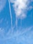 Parallel white trails of airplanes in blue sky