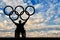 Paralympic disabled person in wheelchair hold olympic rings