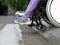 A paralyzed girl in a wheelchair prepares to run over the border in front of a pedestrian crossing. Risk of accident and crash.