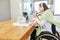 Paralyzed woman in a wheelchair during a video conference in the home office