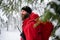 Paramedic from mountain rescue service walking outdoors in winter in forest.