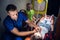 A paramedic puts on an oxygen mask on an unconscious woman lying on a stretcher in the ambulance car