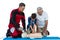 Paramedic training cardiopulmonary resuscitation to senior man and boy