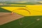 Paramotor close-up seen from the sky over the canola fields with spring sun