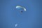 Paramotor rider  up high in the summer skies over a beach .