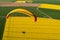 Paramotor seen from the sky over the french colza fields with spring sun