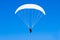 A paraplane flying high up in the deep blue sky