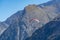 Paraplaners in tandem gliding in blue sky and Alpine mountains on paraplane