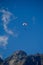 Paraplaners in tandem gliding in blue sky and Alpine mountains on paraplane