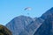 Paraplaners in tandem gliding in blue sky and Alpine mountains on paraplane