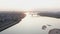 Parasail wing flying on golden sunset horizon landscape. Paraplane flying over river on city bridge architecture background