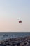 Parasailing in Dubai - single colorful parasail parachute tendem wing flying, towed behind a boat before sunset