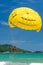 Parasailing is a popular water sport in Patong Beach, Thailand. People flying on colorful parachute towed by speed boat with a cle