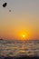 Parasailing silhouette in beautiful sky over the sea water ocean at orange and red sunset, Phuket Island, Thailand