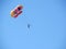 Parasailing water amusement. Beautiful bright blue sky and colorful parachute