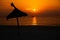 Parasol out of straw at tropical beach in front of the ocean with a boat while sundown perfect location for resting and relaxing