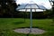 Parasol in the park made of metal and plastic polycarbonate material. the shape of an umbrella from it rains water. Water flows do